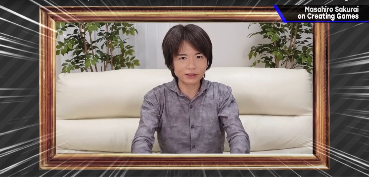 Masahiro Sakurai seated on a cream couch framed by plants in his Creating Games video series